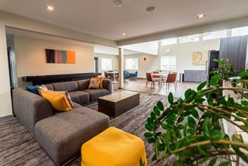 a living room with couches and chairs and a dining room